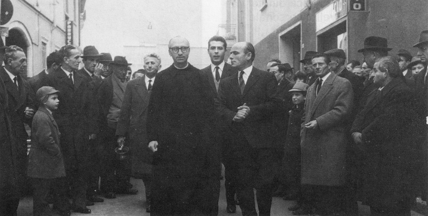 Dicembre 1966, in via Novara per la benedizione del rinnovato salone del Circolo S. Ambrogio; lo accompagnano il sacrestano Angelo Rosa, Sergio Conti e Ambrogio Nisoli. Sulla destra si vedono il Panificio e l'ingresso del cortile nel quale l'autore di questo sito ha abitato per trent'anni